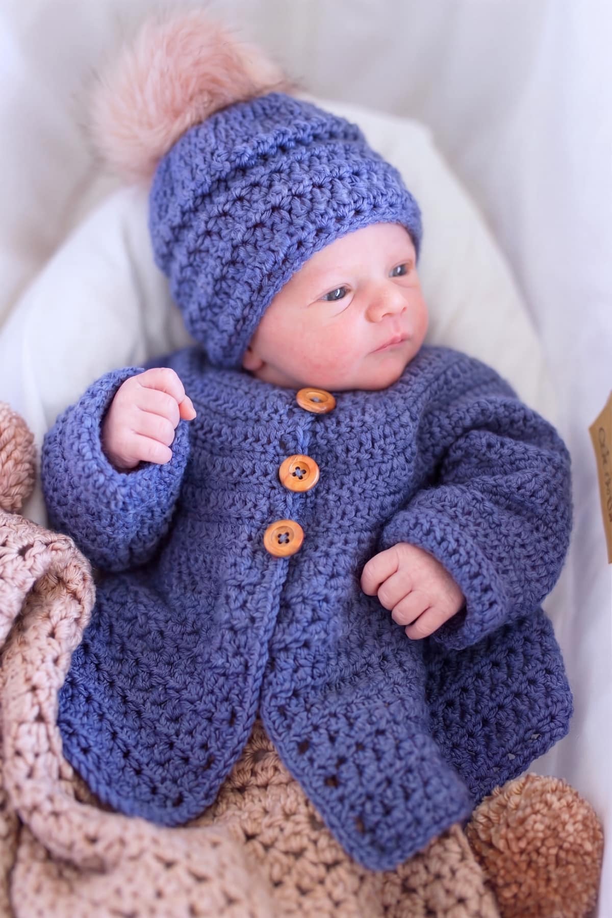 baby wearing the cardigan and hat in stylecraft yarns bambino dk